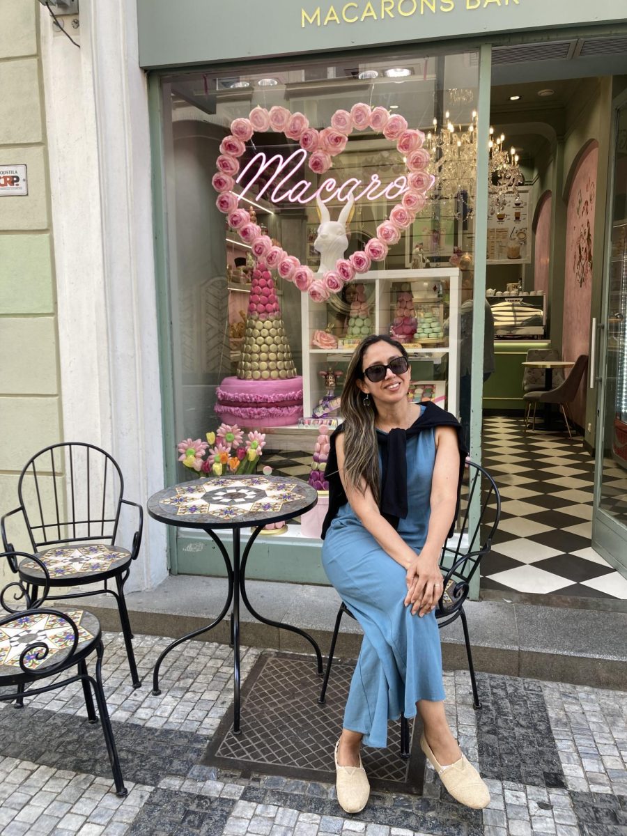 Mrs. Escobar sitting in front of a macaroon bakery in Progue, Czech. Shared by Mrs. Escobar.