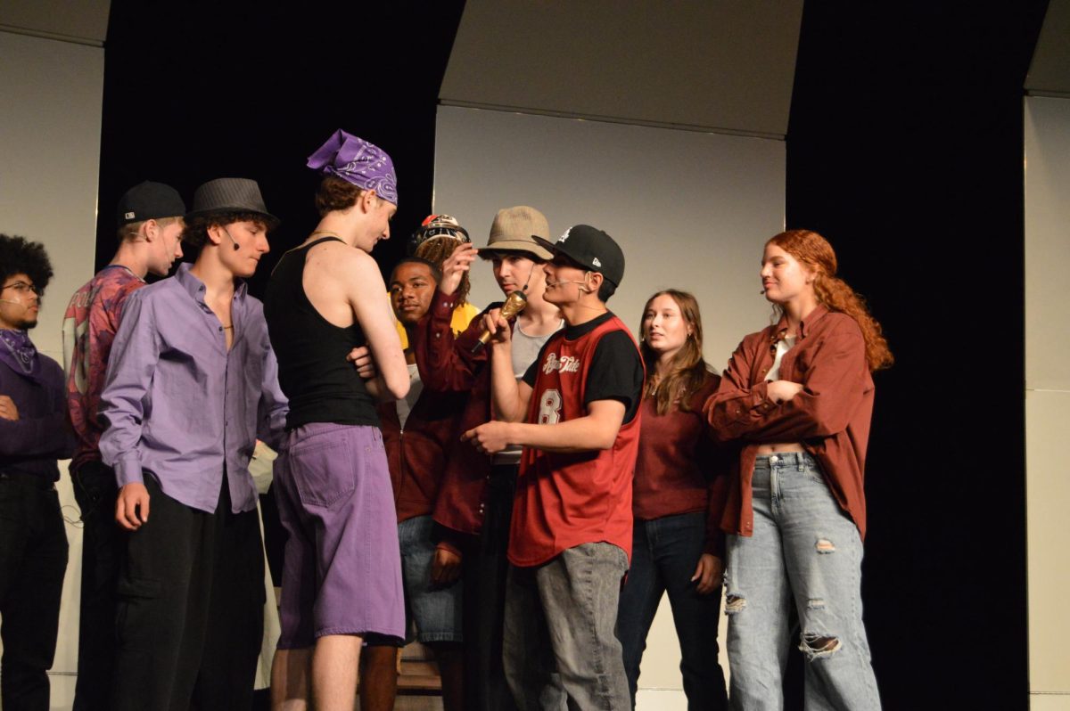 Gavin Bunn, '25, from the Left Side Lyricists, and Julian McEnery, '25, from the Right Side Rhymers, rap battling in the middle of the stage.