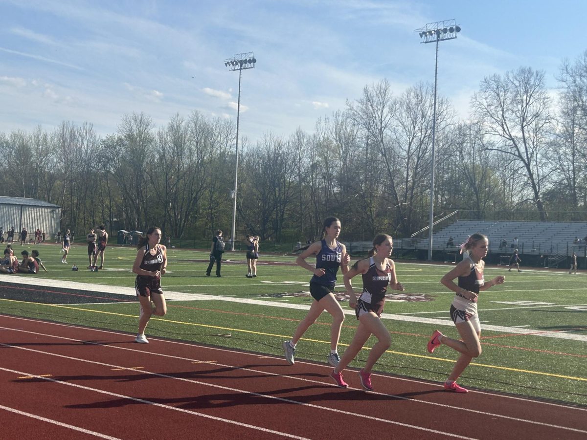 Catharine Brinker, '25, Carolyn Roberti, '25, and BLANK compete in the mile against East Stroudsburg South.
