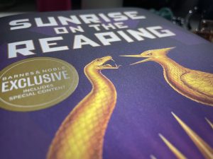 The cover of "Sunrise on the Reaping" zoomed in to the title and the golden animals. 