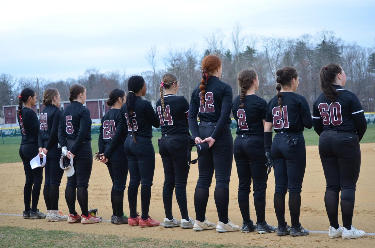 The Stroudsburg Softball team stands on the foul line for the National Anthem. Credit to Victoria Lis/yearbook, shared with permission.