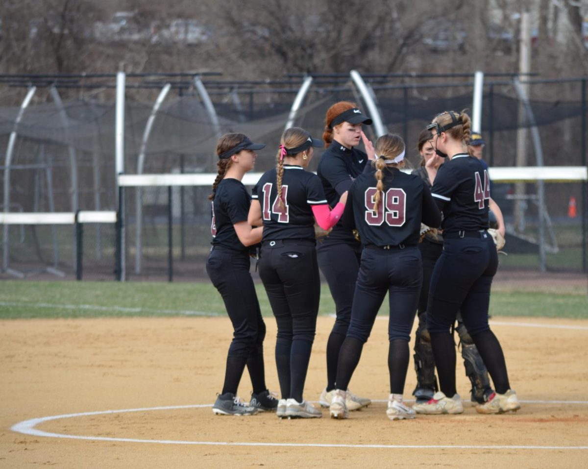 The starting Stroudsburg softball team huddles at the beginning of an inning. Credit to Victoria Lis/yearbook, shared with permission.