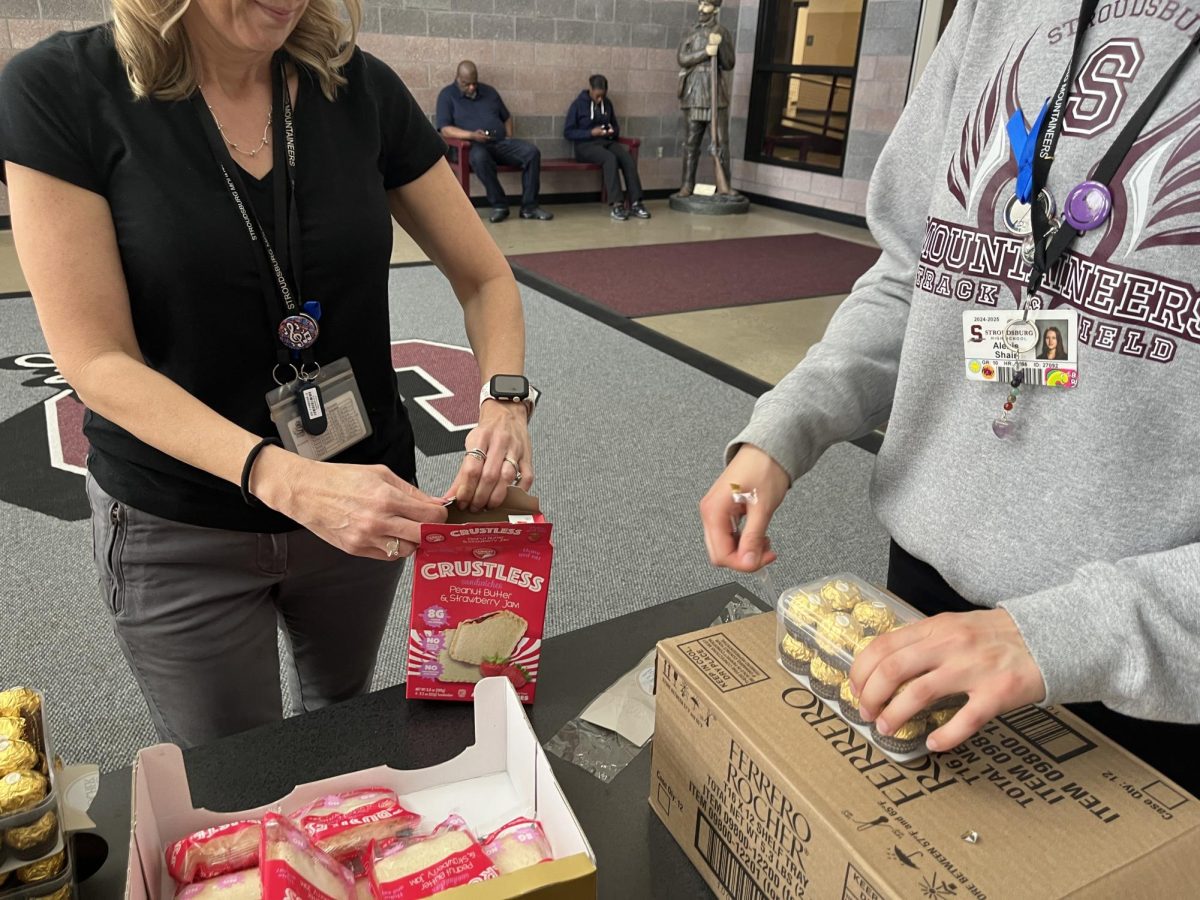 Ms. Gondella (Reading Specialist left) and Alexis Shair ('27 right) unpacking to give to students before they get on the bus Friday.