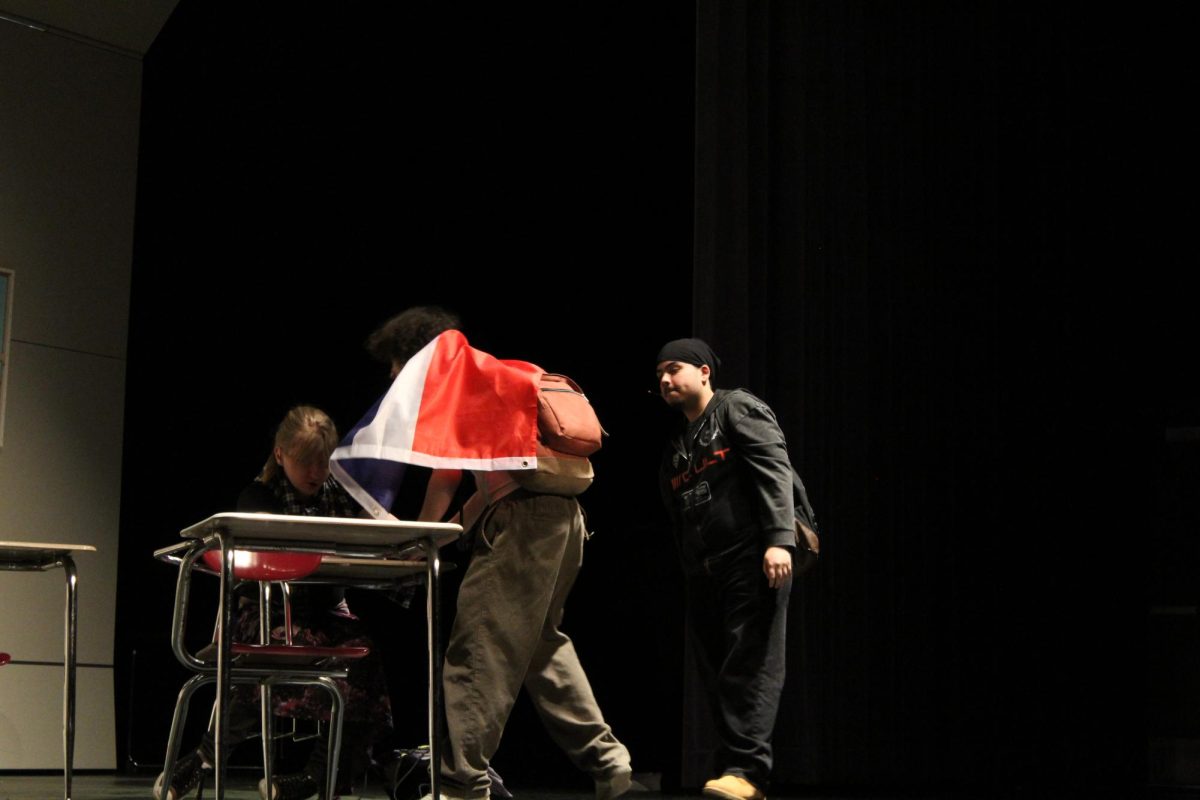 Guac played by Jayden Inoa, '25, gets shoved into a Caus' desk by Spike. 