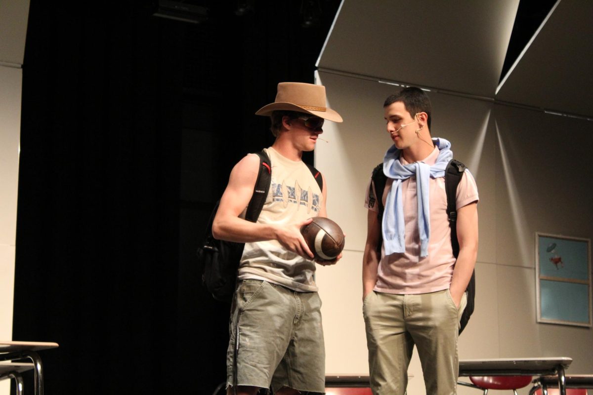 Ben Pilcher, '25, plaus Ricky talking to Lucas Pelaez, '26, who plays Bobby about football before they become aliens. 