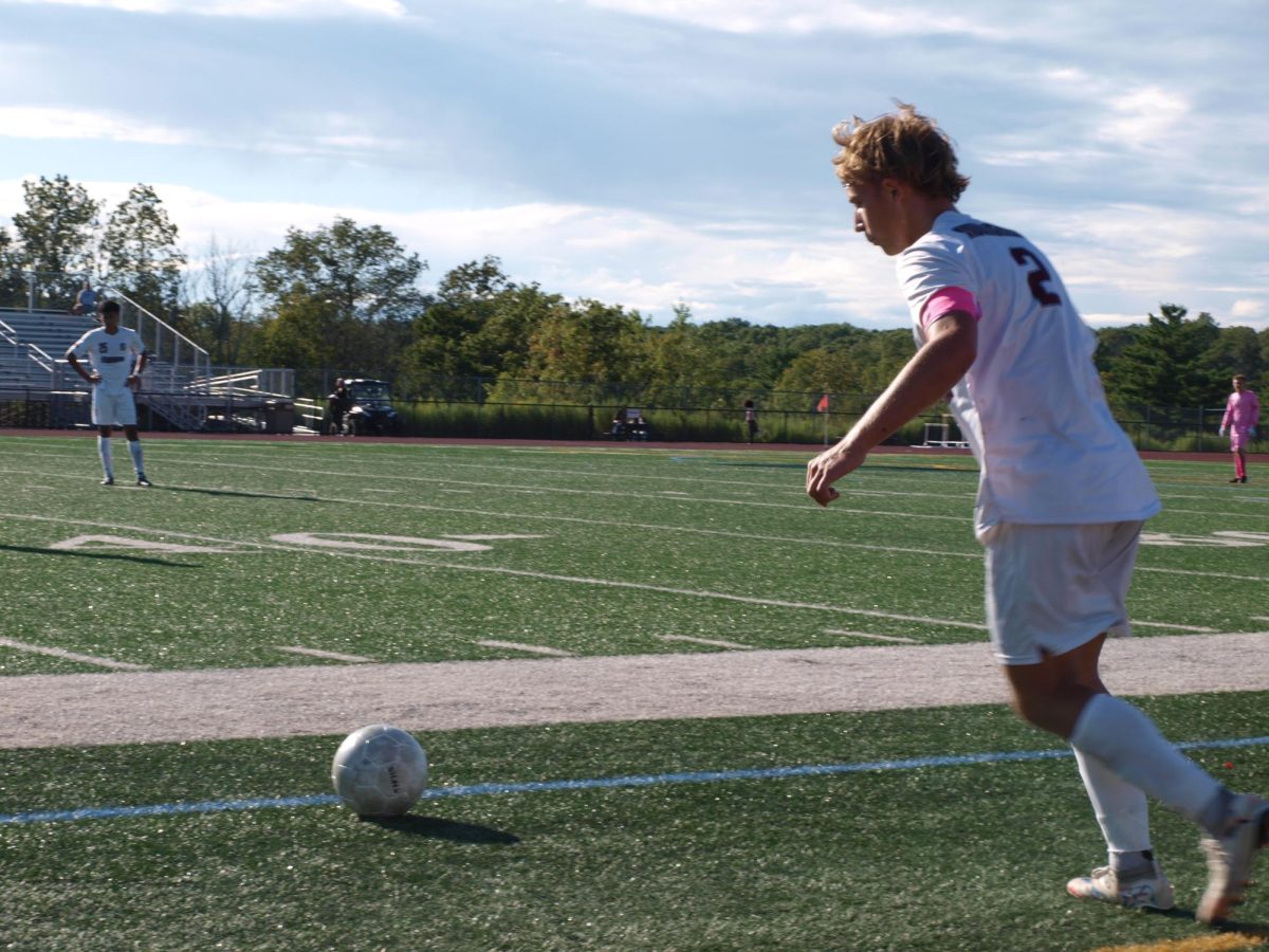 Varsity captain Kaidhn Schatzman, '26 approaching the ball for a long pass.