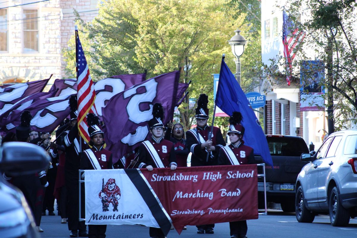 The pit of the marching band carrying the banner at the front of the parade.