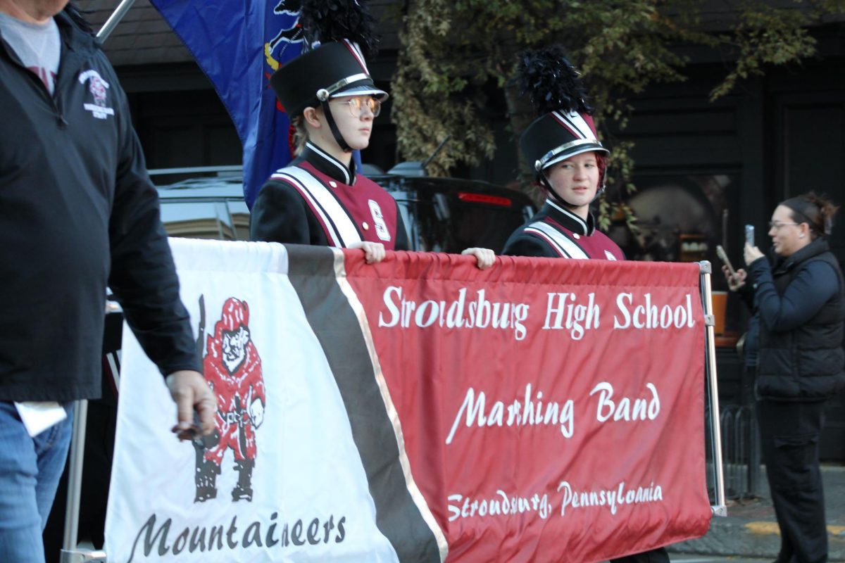 Izzie Miller, '26 and Callum Bross, '27 holding the marching band banner.