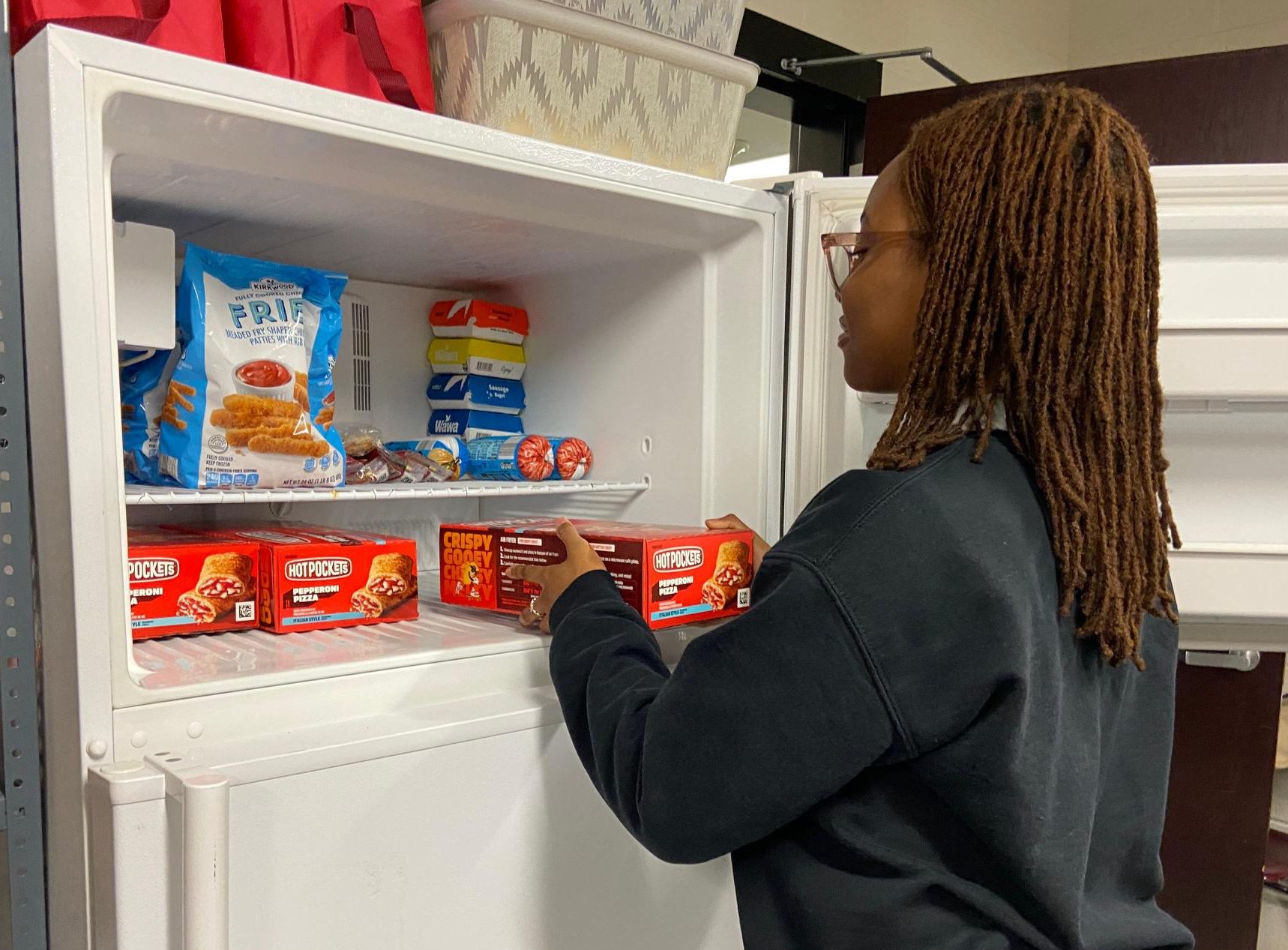 FBLA member opens the new fridge in the food pantry to check stock.