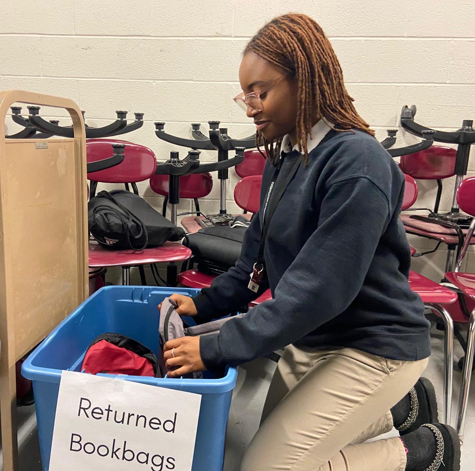 Hailey Abba, a member of FBLA, organizing the returned backpacks bin.