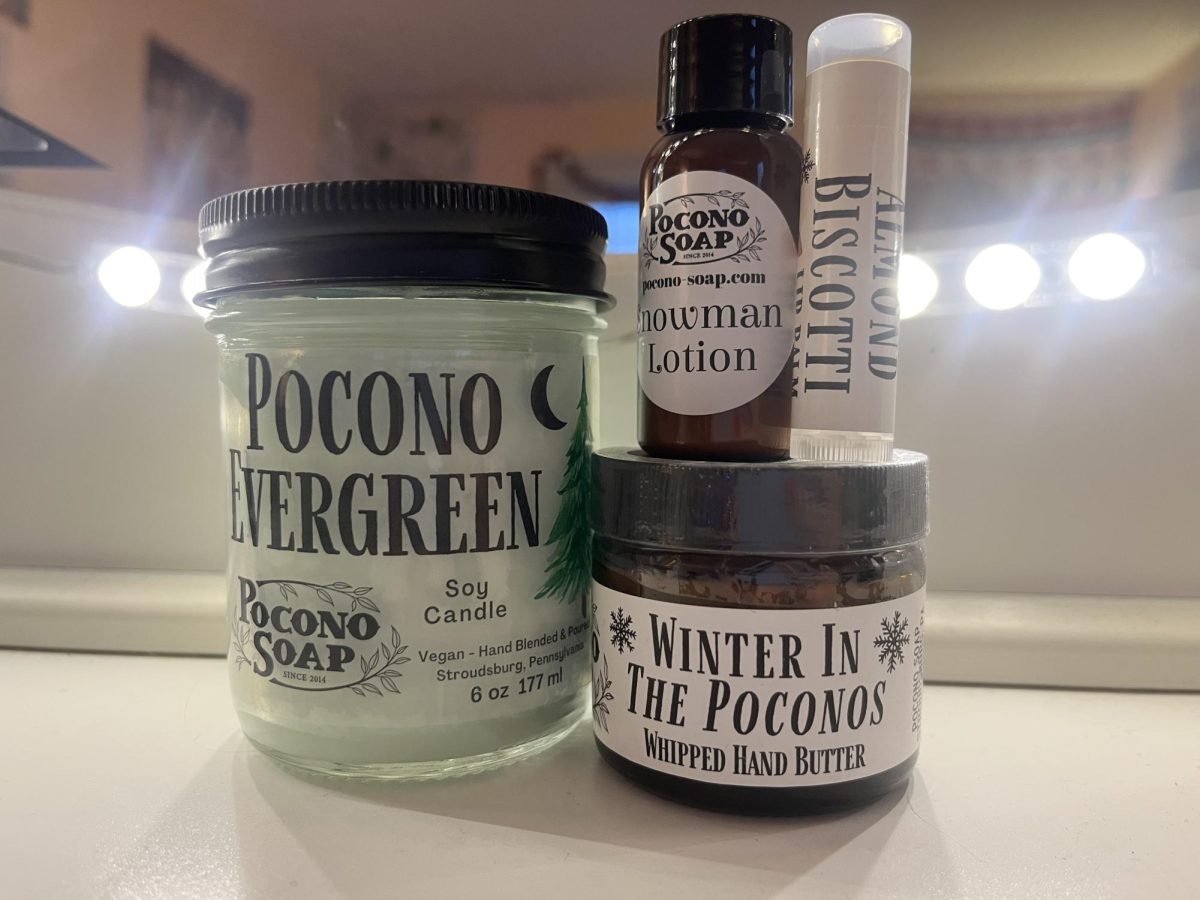 An assortment of Pocono Soap products such as lotion, chapstick, and a candle.
