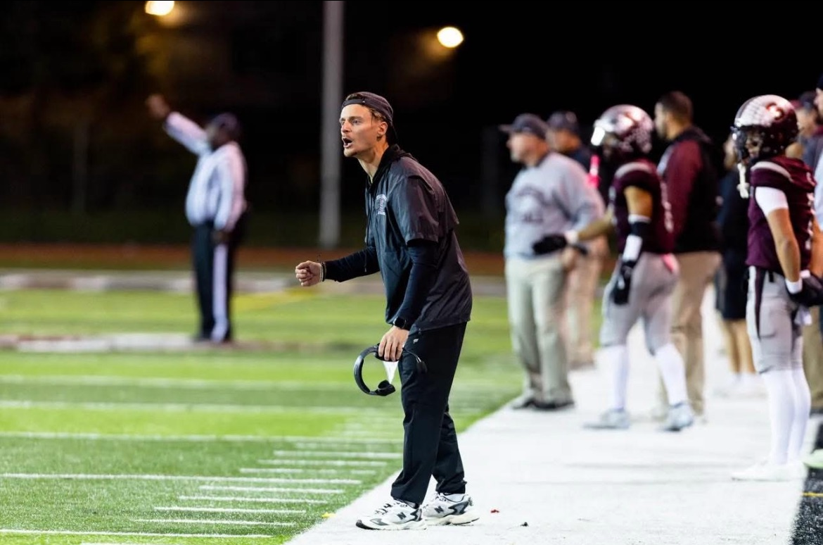 Coach Benny instructs the defense on the sideline.